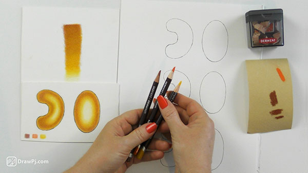 Three coloured pencils being held